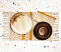Boho ochre, blush, and cream striped woven fringe placemats set.  With dinnerware and fringe woven napkins.