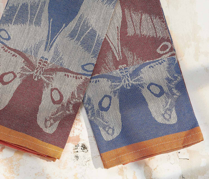 Two fabric swatches with butterfly pattern on a textured surface