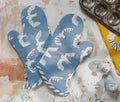 Blue oven mitts with bird pattern on a textured surface with baking tools - lollygag