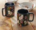 Two black mugs with cat designs on a wooden table - lollygag