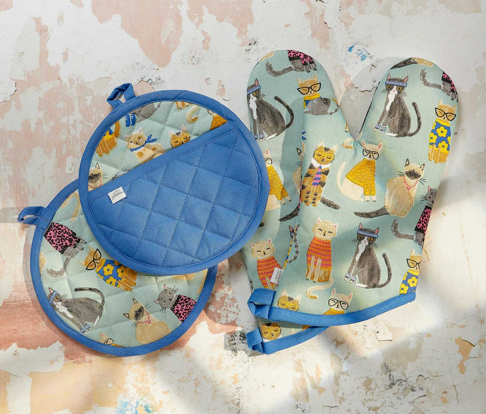 Set of oven mitt and pot holder with cat pattern on a textured surface