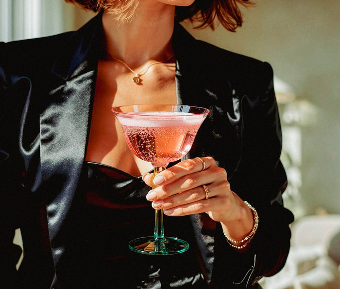 women holding a colorful pink cocktail in a stylish setting
