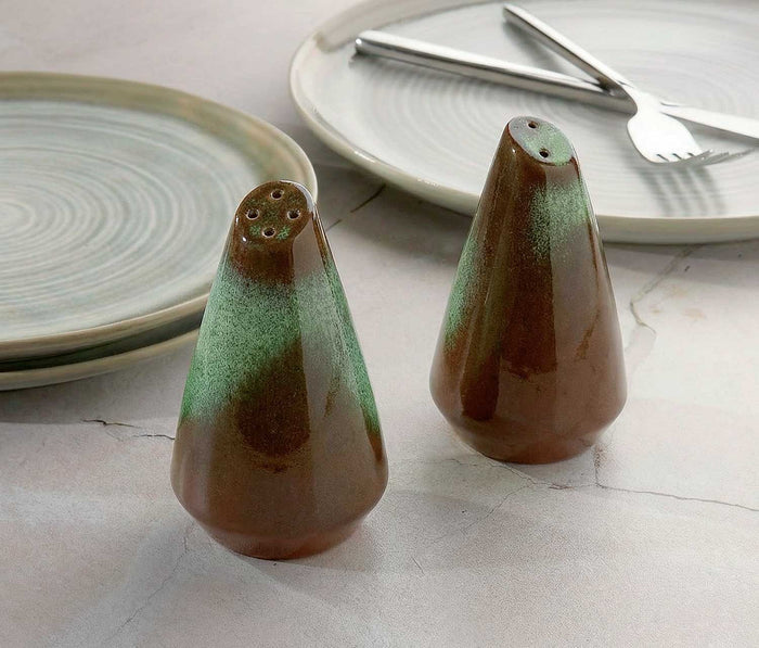 Two ceramic salt and pepper shakers with a concrete finish surface.