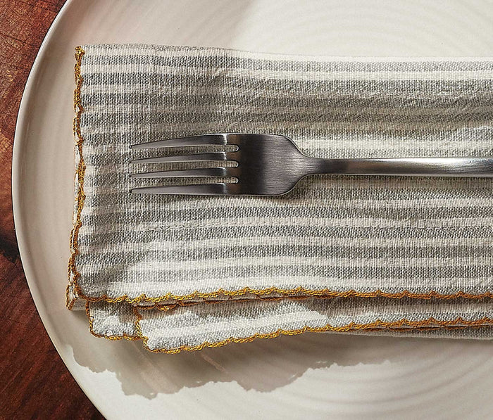 Silver fork on a striped cloth napkin on a white plate