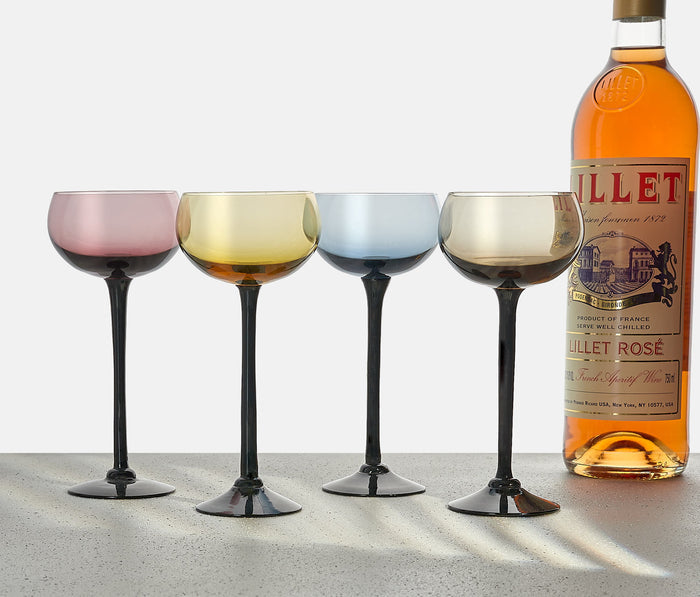 Set of four vintage MCM Madeira Sunset hand-blown wine glasses from Portugal featuring amber, green, yellow and pink bowls with black stems.