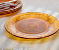 Amber glass plate with floral patterns on a textured surface - Lollygag