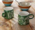 photo of a  green ceramic mug featuring embossed botanical fern and mushroom pattern